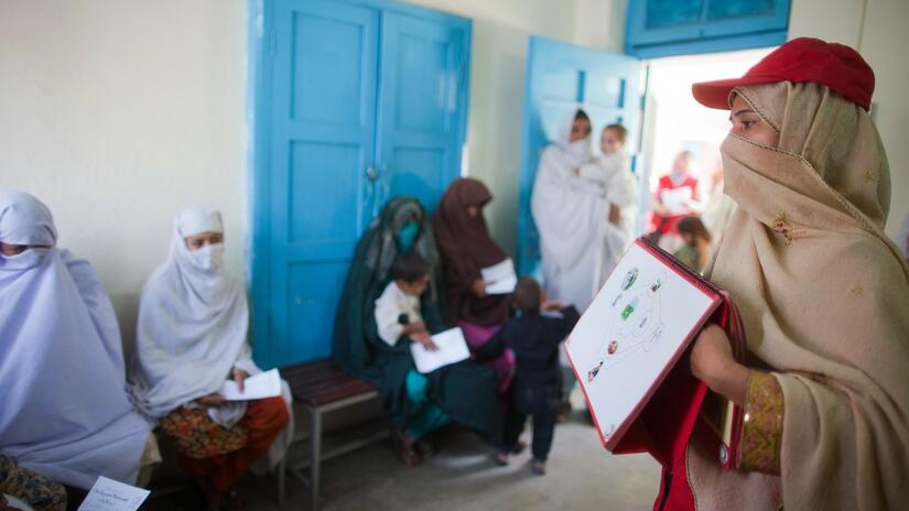 A Pakistan Red Crescent volunteer leads a hygiene lesson with women waiting to see a doctor at a health clinic in the north of the country