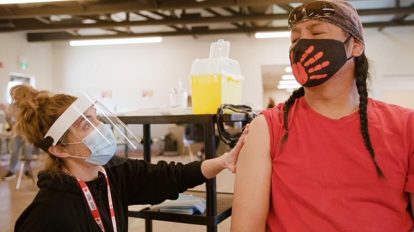 A Canadian Red Cross nurse administers a COVID-19 vaccine to a patient in Manitoba