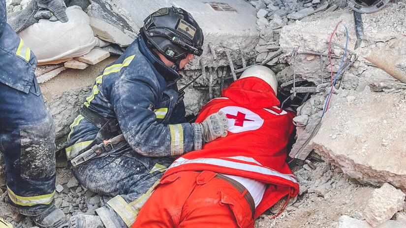متطوع من فريق البحث والإنقاذ في الصليب الأحمر اللبناني يسحب شخصًا من تحت الأنقاض في أعقاب الزلزال الذي ضرب تركيا وسوريا. 
