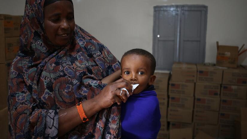 Little Maslah Yasin Usman eats Plumpy'Sup, a high-calorie nutritional supplement for moderately malnourished children, in a Somali Red Crescent Society clinic in Burao.