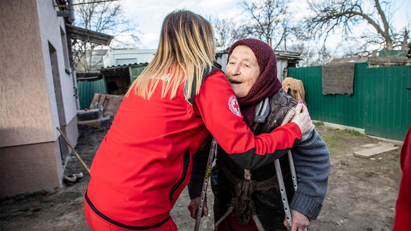 An Italian Red Cross volunteer hugs a Ukrainian woman in March 2023 in Zhytomyr, Ukraine, where the Italian Red Cross has donated a mobile health unit to provide health services to the local community.