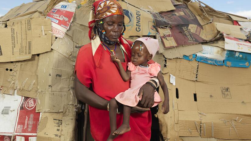 Deolinda from Angola holds her baby granddaughter who she carried on a ten-day trek to Namibia in search of food.