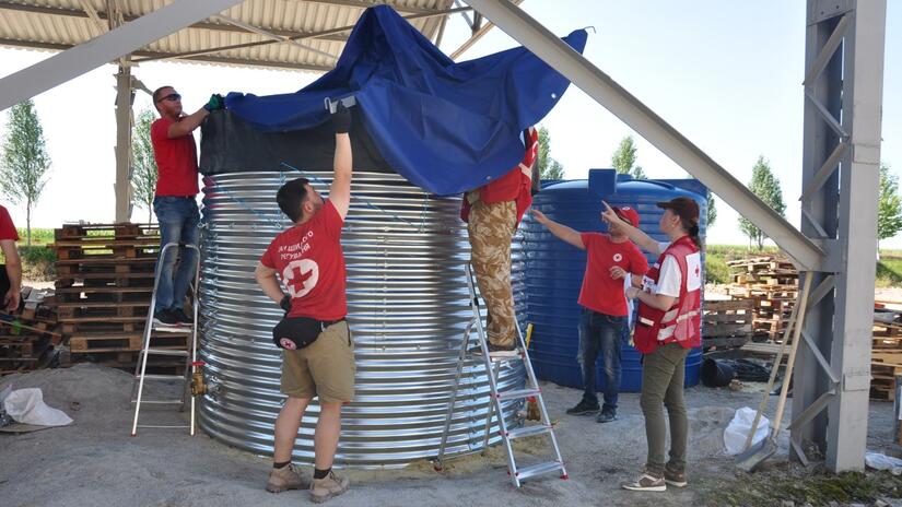 Ukraine Red Cross and members of an IFRC Emergency Response Unit set up a water storage system in the summer of 2023. 
