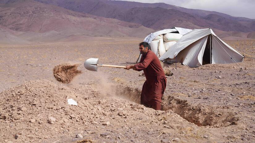 Dans le but de garder ses enfants au chaud et à l'abri des vents hivernaux, Abdul Qayoum creuse le sol dur pour aménager un abri de fortune.