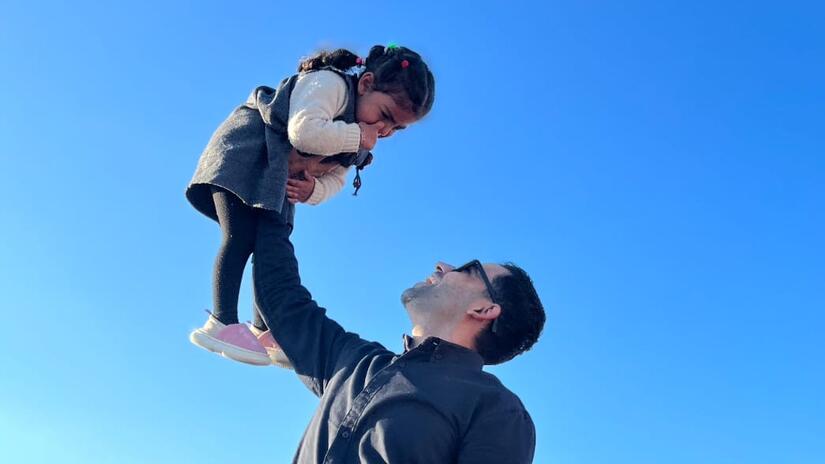 عمرو مع ابنته ماريا خلال فعالية نُظمت للأطفال في المخيم الذي يقيمون فيه في رفح. 