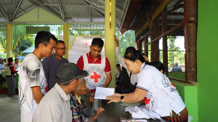 Dr. Chaw Khin talks with people impacted by Cyclone Mocha in 2023 during a cash distribution aimed at helping them get back on their feet after the storm. 