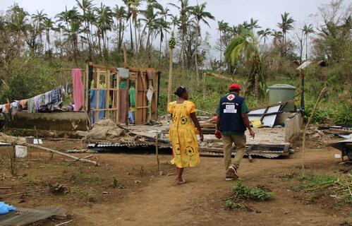 Vanuatu Red Cross volunteer surveys the damage of Cyclone Lola. with a local resident. 