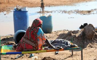 A woman in Sudan affected by heavy flooding in 2020 is forced to sleep in the open after her home is damaged