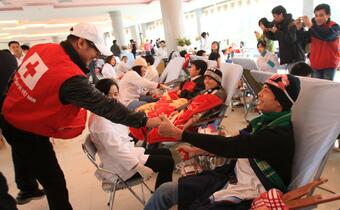 IFRC Goodwill Ambassador Jet Li shakes hands with a young blood donor at the Vietnam Red Cross Societies annual spring festival which aims to recruit new blood donors to meet the country’s blood shortage during the lunar New Year