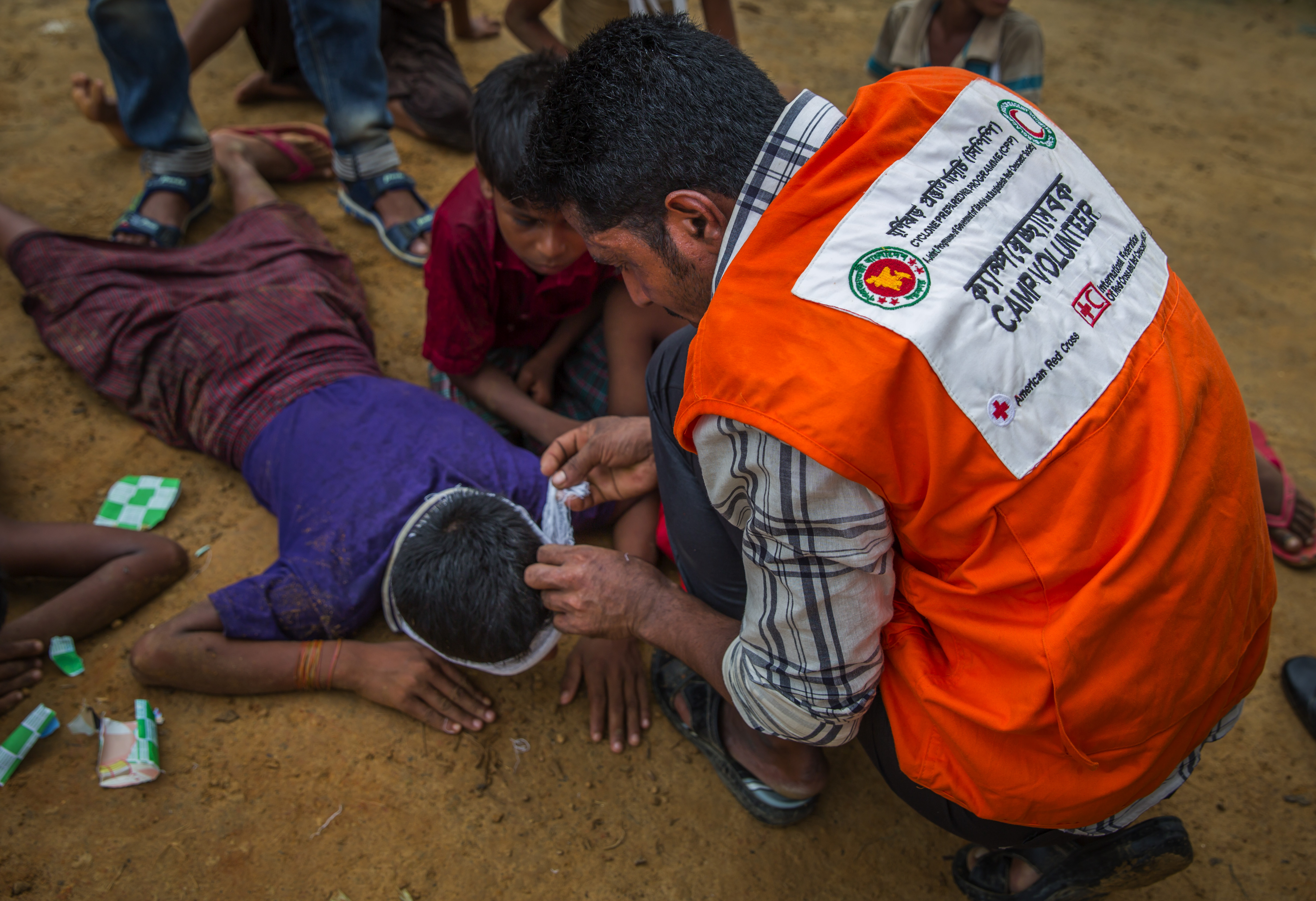 In this file photo from June 22, 2018, a volunteer demonstrates his first aid skills at a disaster simulation drill in Coxs Bazar, Bangladesh. The drill is helping to prepare residents of Kutupalonga 