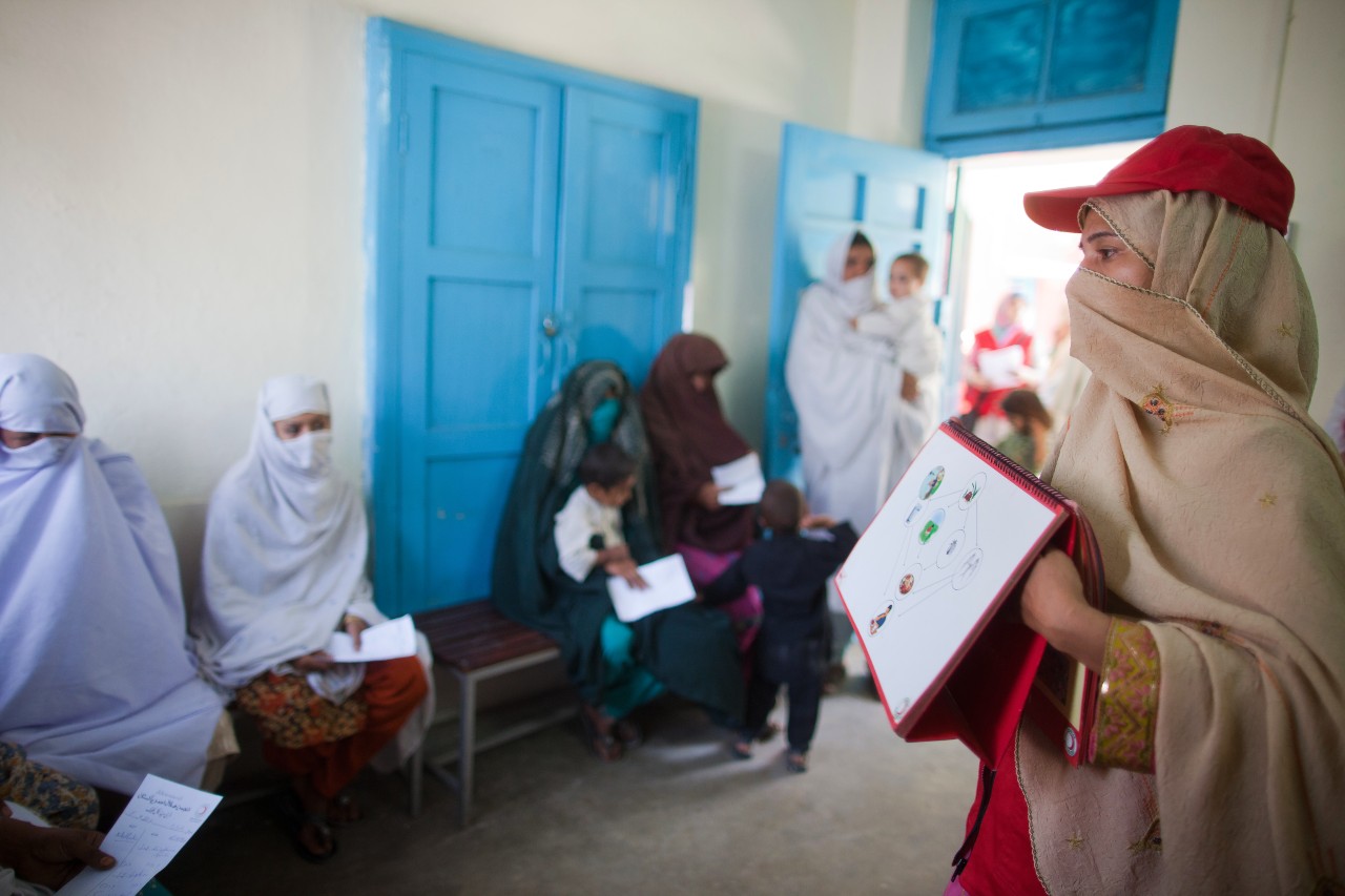 Un volontaire du Croissant-Rouge du Pakistan donne une leçon d'hygiène à des femmes qui attendent de voir un médecin dans un dispensaire du nord du pays