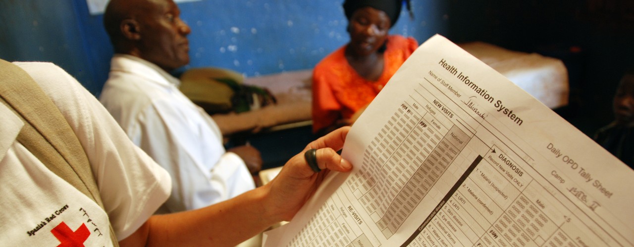 A Spanish Red Cross health worker holds a chart detailing outpatient treatment and malaria diagnosis