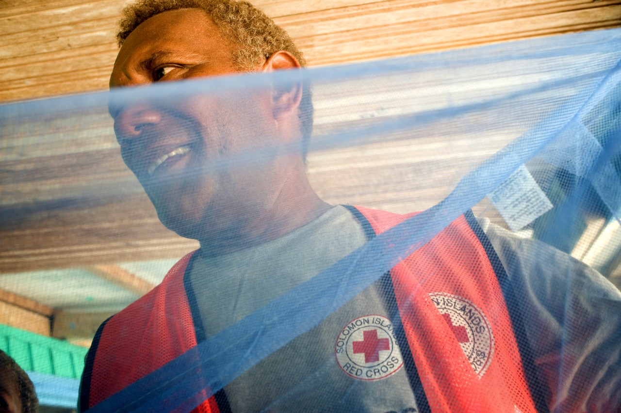 A Solomon Islands Red Cross volunteer helps distribute bed nets to communities in preparation for malaria season