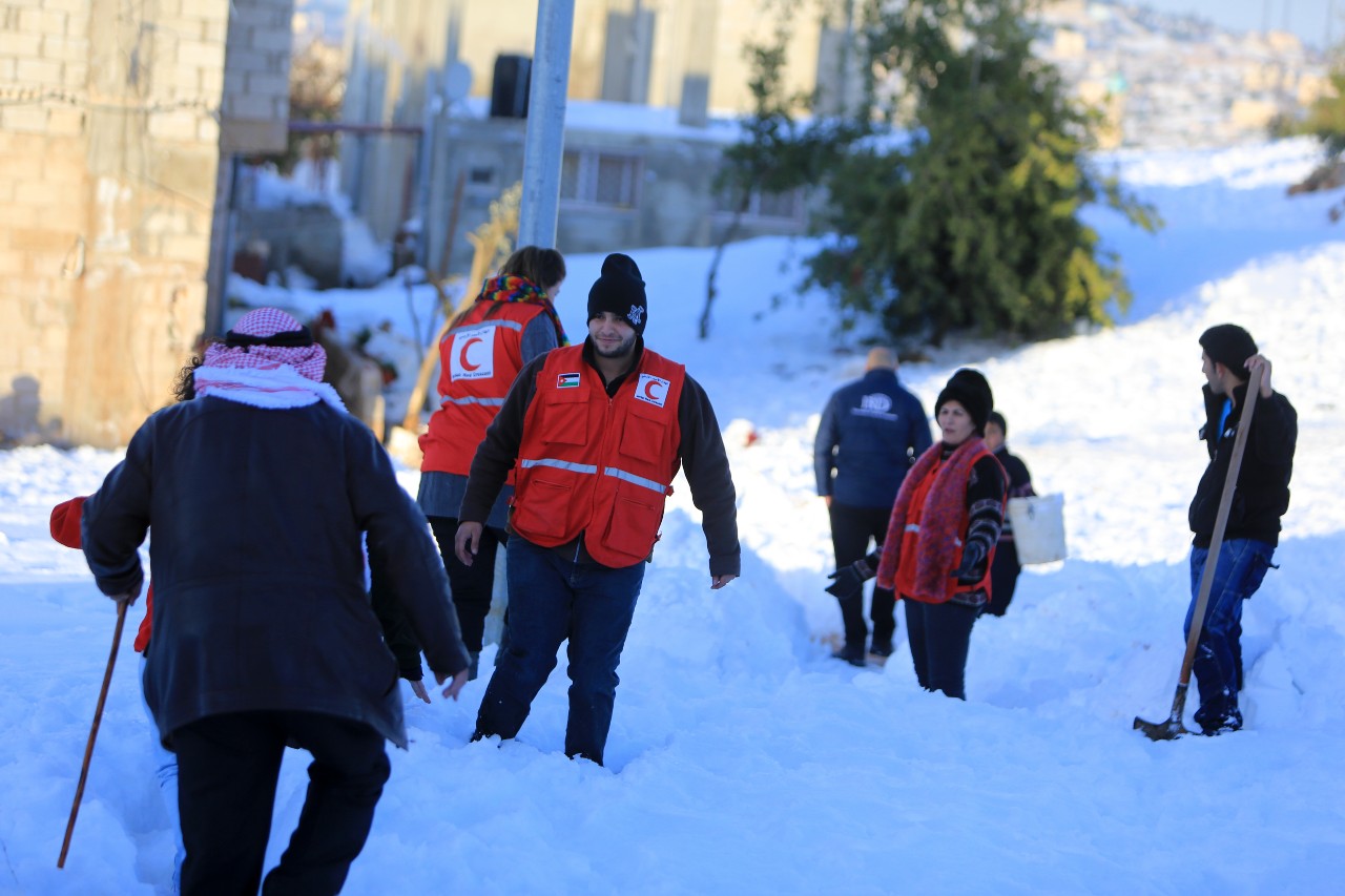 Des volontaires du Croissant-Rouge jordanien traversent Ajloun en 2013 à la suite d'une forte tempête de neige pour évaluer les besoins des communautés locales et les aider à surmonter les conditions difficiles