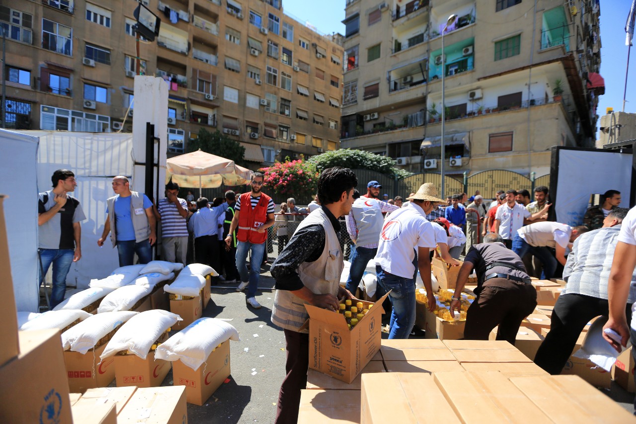 Voluntarios de la Media Luna Roja Árabe Siria distribuyen suministros de socorro a las comunidades en 2013