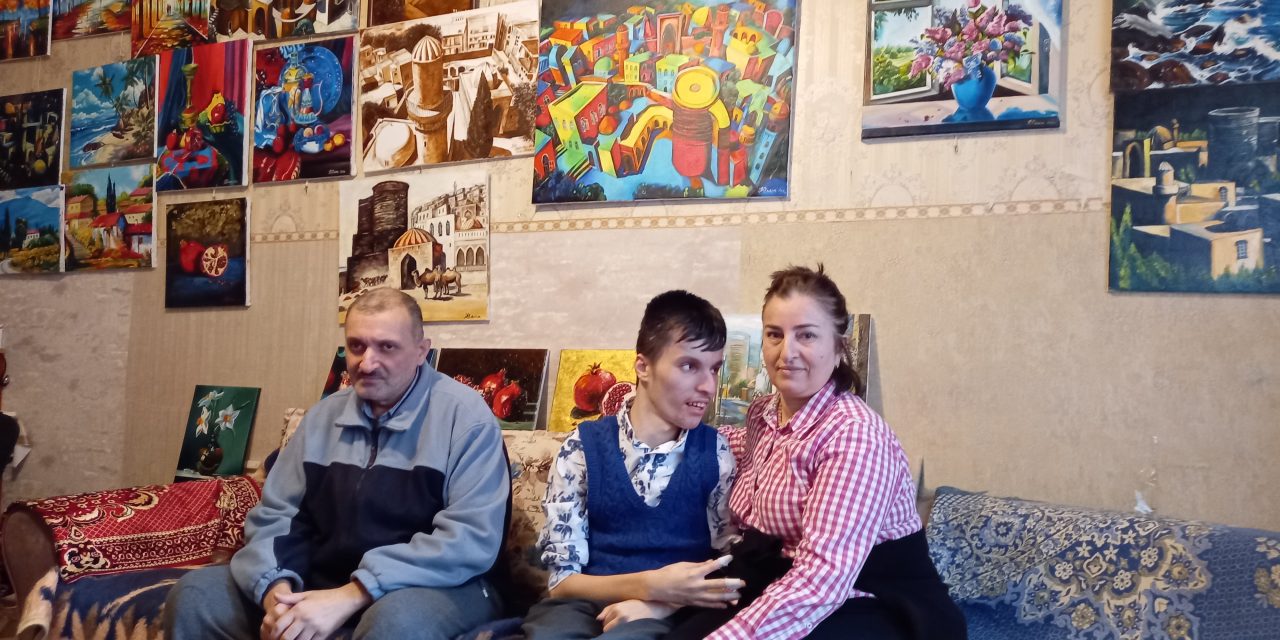 Şiriyeva Rəxşəndə sits with her son Fuad and husband Rəxşəndə in their home