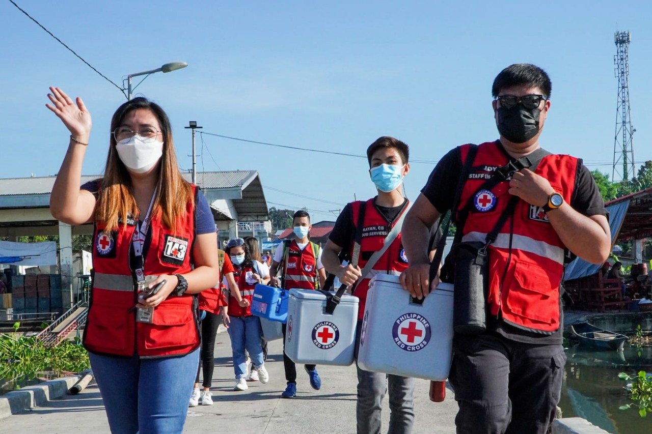 Philippine Red Cross volunteers cross muddy terrain and water to reach people living on remote islands and isolated areas with life-saving COVID-19 vaccines.