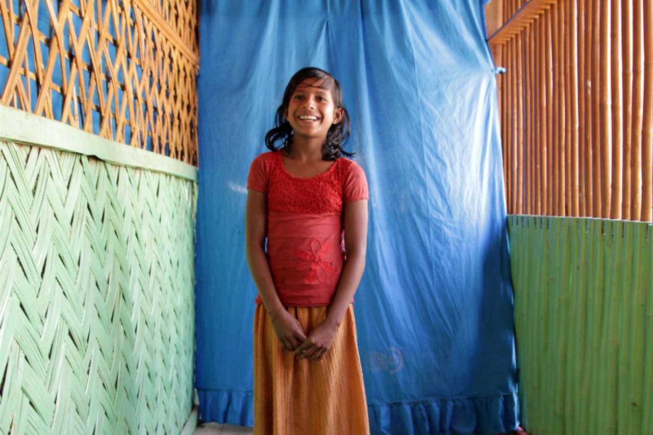 Minara, a girl from Myanmar stands in a community safe space in Burmapara camp, Cox's Bazar where she plays, reads and embroiders with her friends.