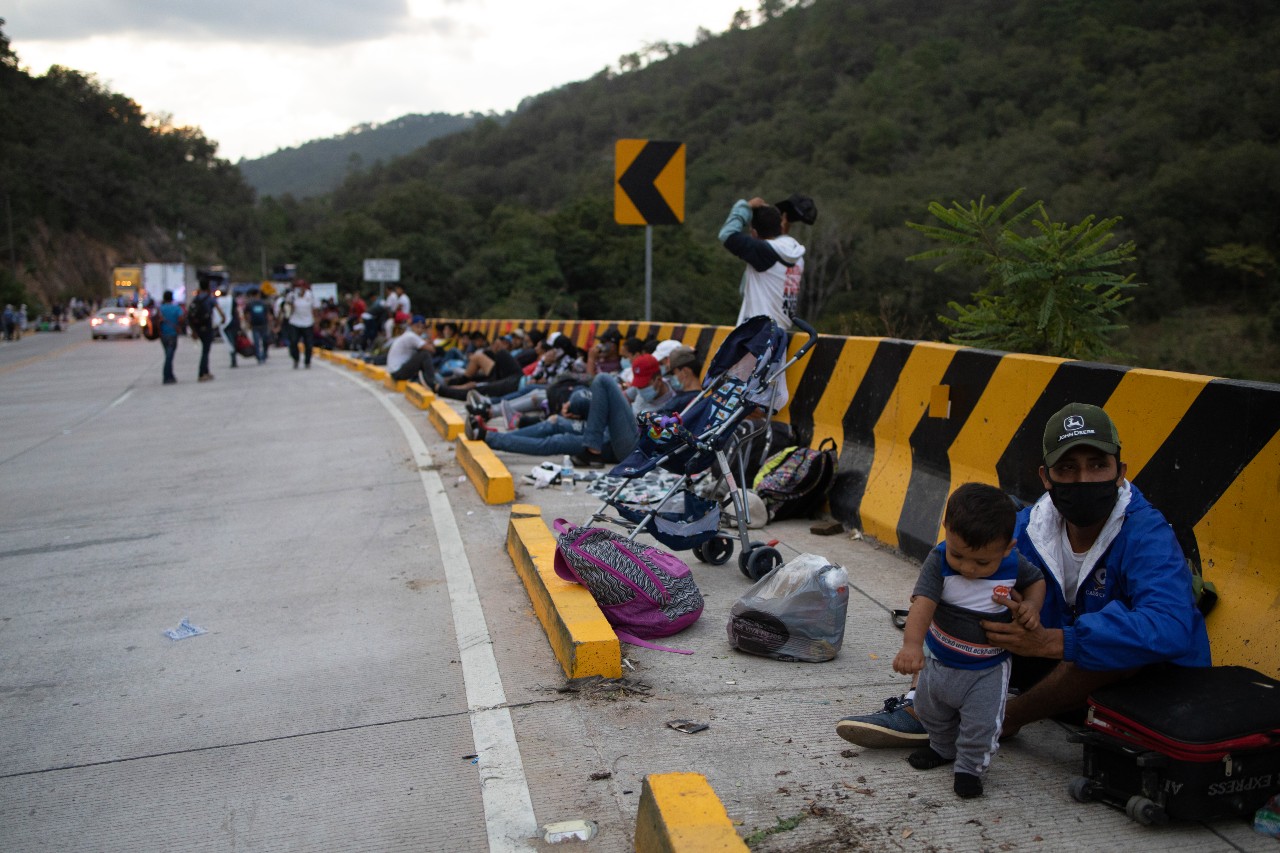 Varias personas se reúnen a un lado de la carretera en San Pedro Sula, Honduras, mientras se preparan para emprender un viaje hacia el norte a través de Guatemala y más allá en busca de una vida mejor. 