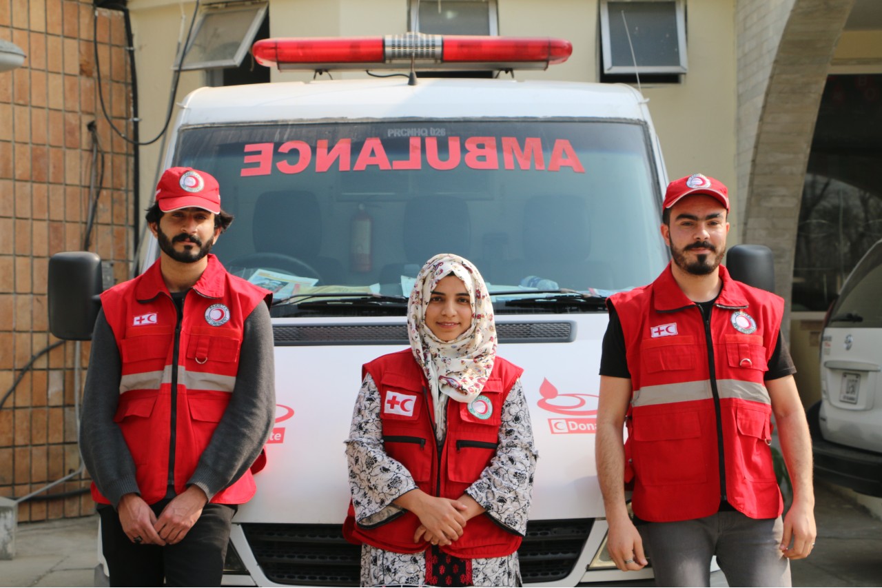 Pakistan Red Crescent Society volunteers stand next to an ambulance outside the National Society's headquarters in Islamabad
