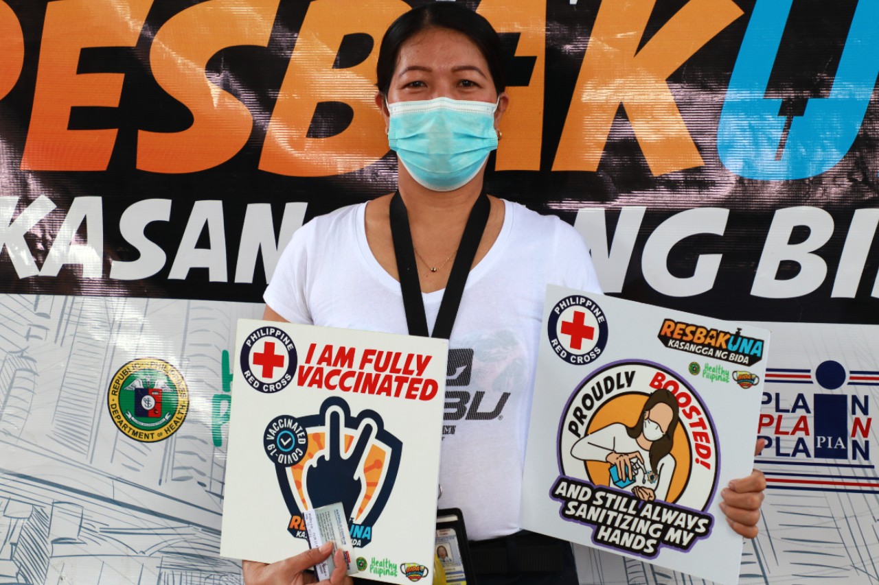 A woman in the Philippines poses for a photo following her second COVID-19 vaccine administered by the Philippine Red Cross in April 2022. The Philippine Red Cross is helping vaccinate the population through 26 vaccination sites and 17 mobile clinics across the country, ensuring even remote communities can get their jab.