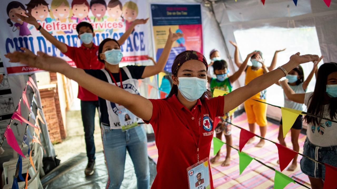 Philippine Red Cross youth volunteers lead a group of children in Santo Domingo in fun and dancing activities to help them stay safe from COVID-19 and cope with the effects of recent typhoons.