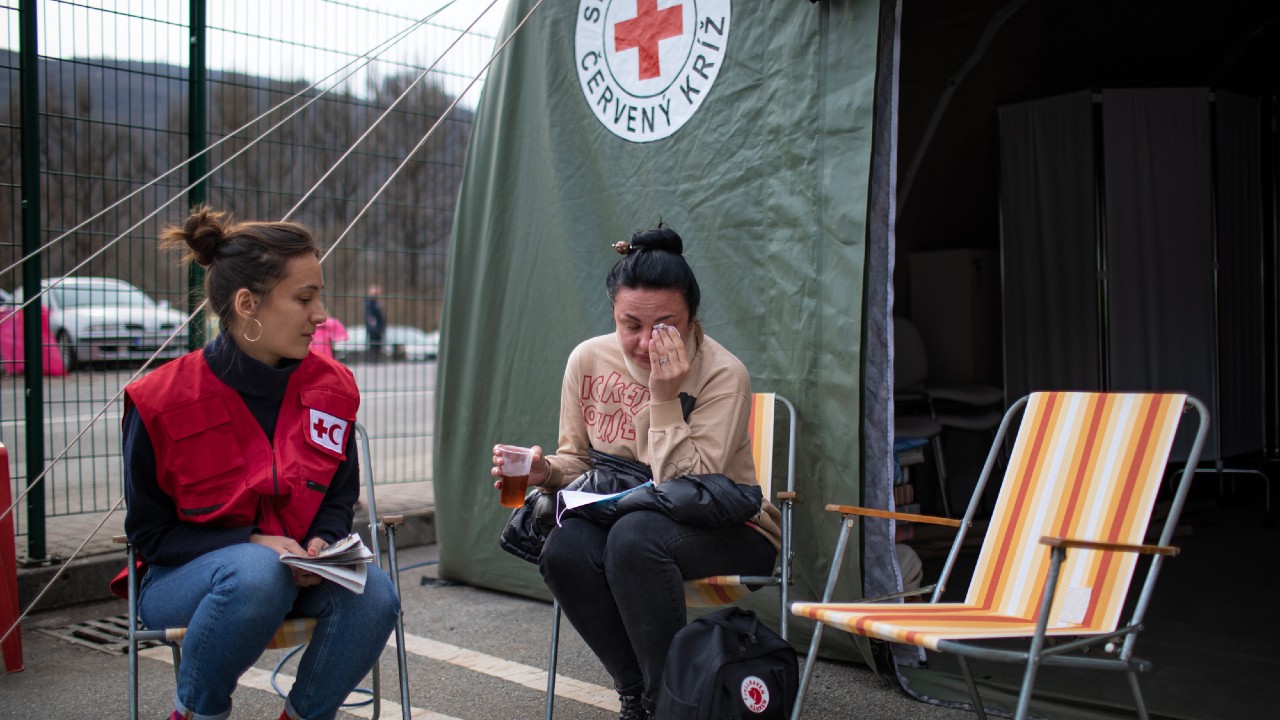 Iryna from north east Ukraine sits in a Slovak Red Cross assistance point close to the border with Ukraine in late March 2022. She speaks to an IFRC delegate about her journey and how her life has been turned upside down by the conflict in her home country.