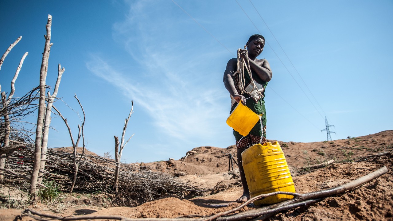 31-year-old Alzira collects water from a near empty water hole in the district off Mabalane, Mozambique.