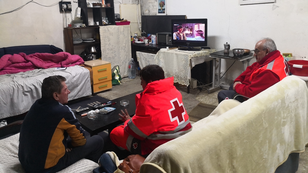 Les volontaires de la Croix-Rouge espagnole, Juani et Basilio, apportent un soutien psychosocial à un sans-abri vivant dans un entrepôt de la banlieue de Madrid. Ils lui offrent de la nourriture, de l'eau et un abri.