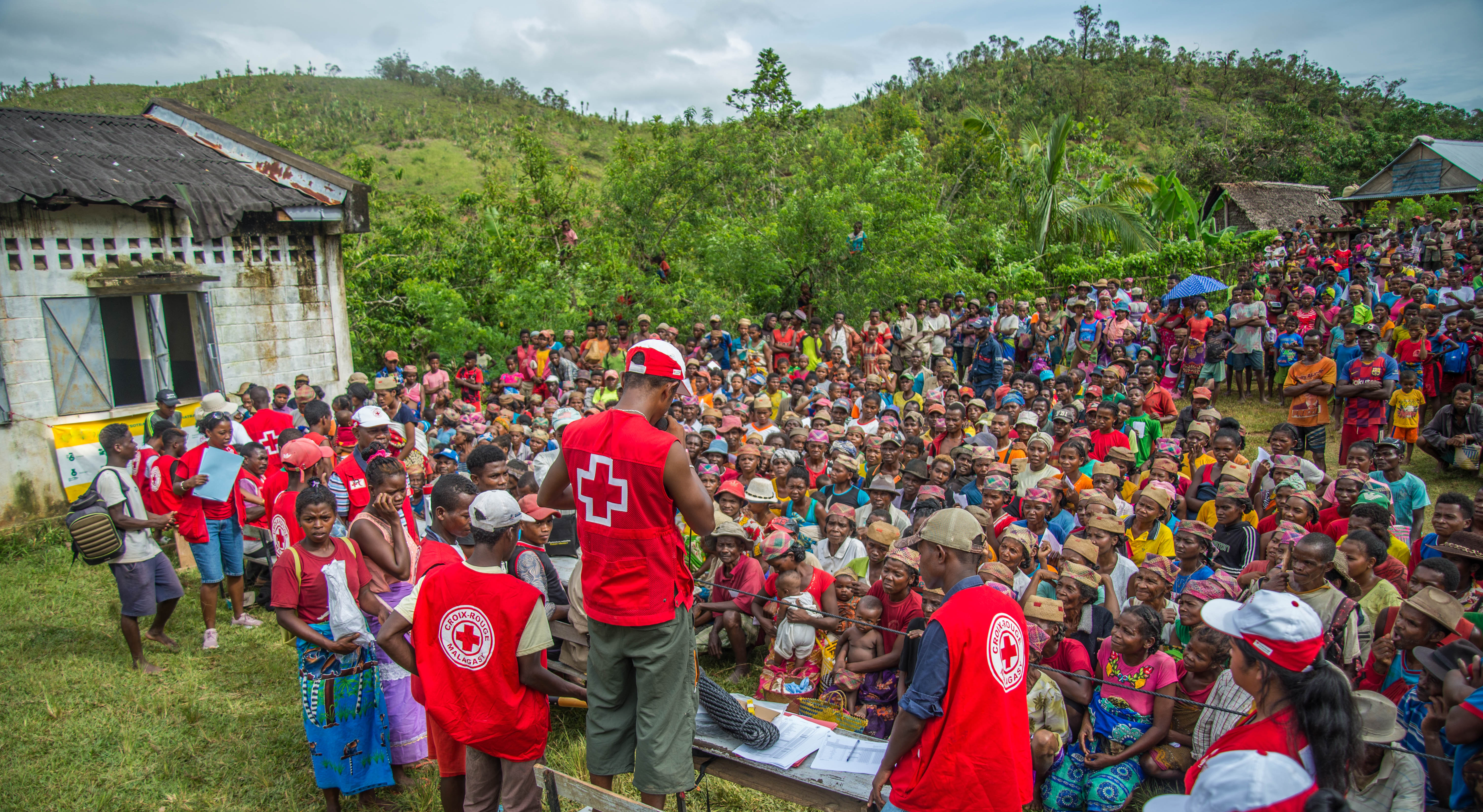 Varias personas voluntarias de la Cruz Roja Malgache hablan con los habitantes de la comuna rural de Sandrohy (Madagascar) sobre la asistencia que prestan tras la devastadora tormenta tropical y el ciclón de principios de 2022.