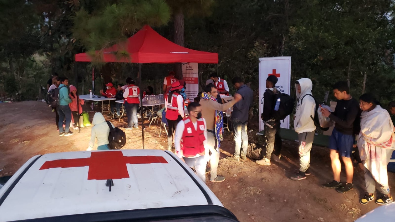 People on the move through Honduras wait in line to be greeted by, and receive support from, Honduran Red Cross volunteers at a Humanitarian Service Point in the west of the country in early 2023.
