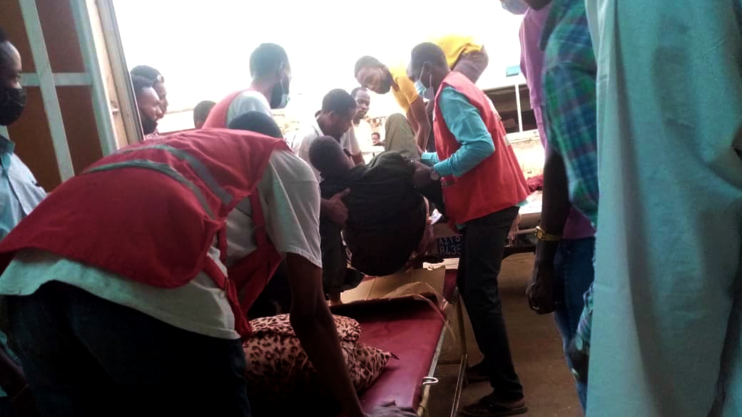 Sudanese Red Crescent Society volunteers assist a man injured during fighting in the country in April 2023 off of a stretcher and into a hospital to receive urgent medical attention.