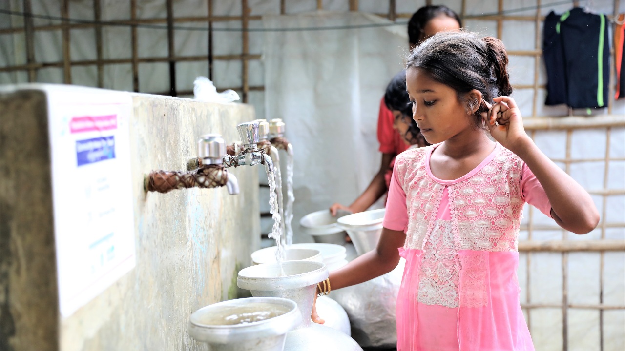 A young girl living in Cox’s Bazar, Bangladesh collects clean water from one of several newly-installed pumps constructed by the Bangladesh Red Crescent, Monaco Red Cross and IFRC in 2023 to make clean water more accessible.