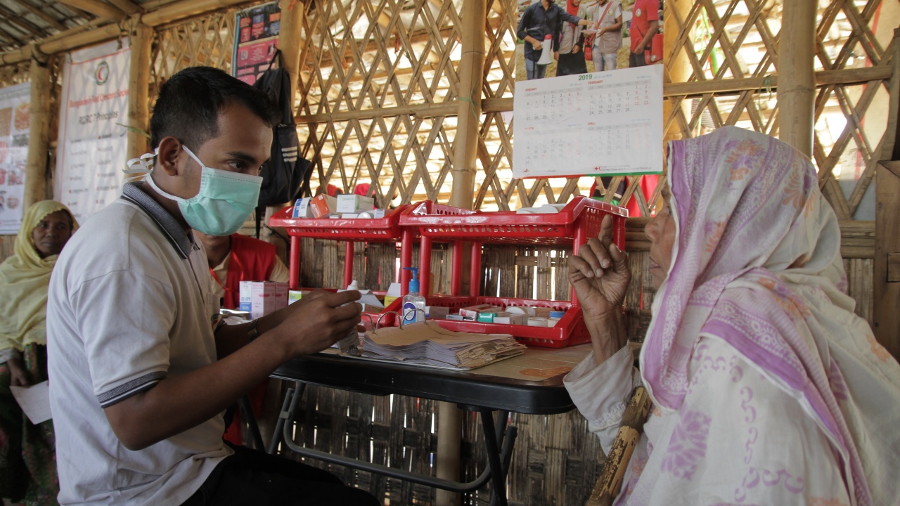 An elderly woman sees the pharmacist at a health post run by the Bangladesh Red Crescent Society in Burmapara camp, Bangladesh.