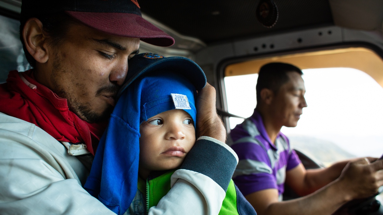Juan holds his son Santiago tight as they make their way from Venezuela to Colombia in search of a better life.