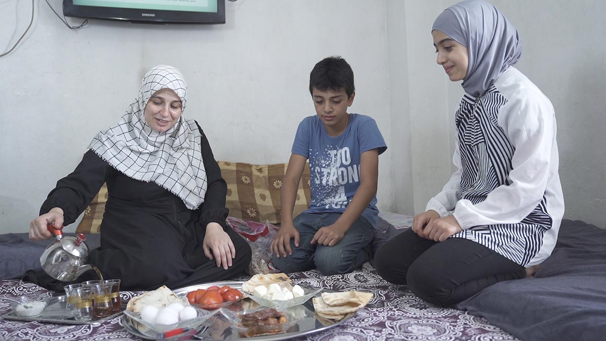Houda and two of her children enjoy a meal and a conversation together