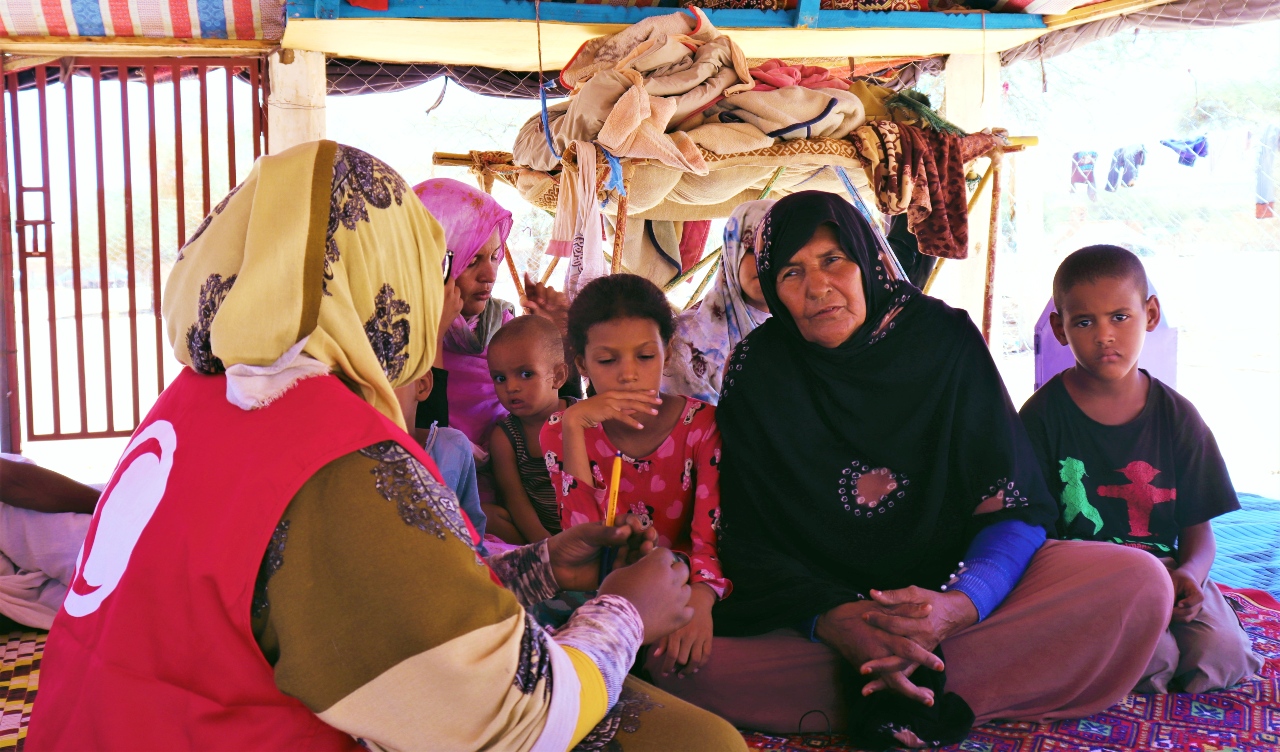 Una persona voluntaria de la Media Luna Roja Mauritana habla con la viuda Zeinab, en N'Beika (Mauritania), que actualmente depende de familiares para sobrevivir y alimentar a su familia durante un periodo de inseguridad alimentaria en el país.