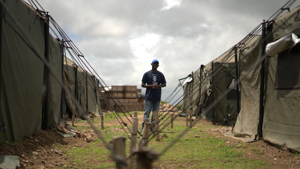 Samuel from Nigeria stands amid tents set up for migrants near the Costa Rican border with Nicaragua, where he rests ahead of continuing his journey north to the United States.