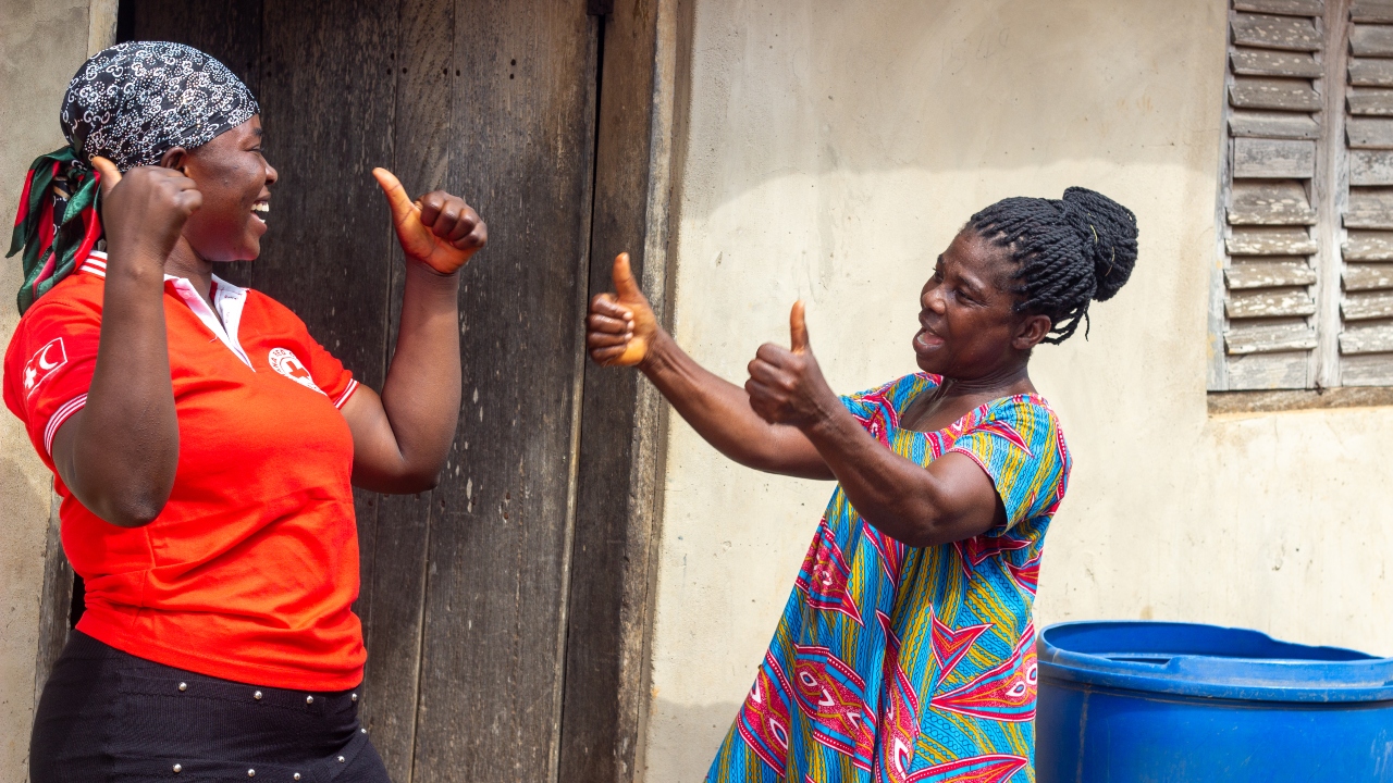 Joyce Oforiwah from Obretema, eastern Ghana, gives a big thumbs up to a Ghana Red Cross volunteer who helps ensure her village has access to safe, clean drinking water.