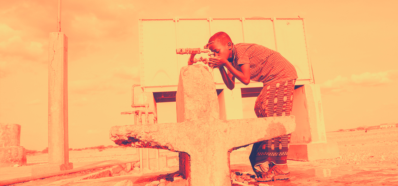 A boy drinks from a borehole in the Semade region of Somalia during a period of extreme heat in July 2022.
