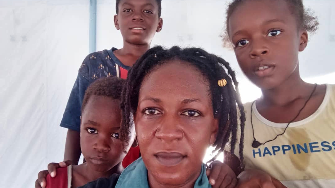 Lia and her three children huddle together in a camp in Port Sudan where they are seeking safety from fighting that broke out in the country in April 2023.