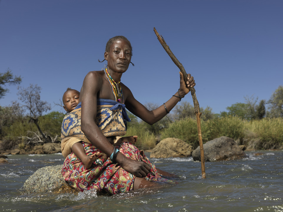 Usenia from Angola stops to rest in the Kunene River as she makes her way on foot to Namibia, where she seeks a better life and more stable sources of food.