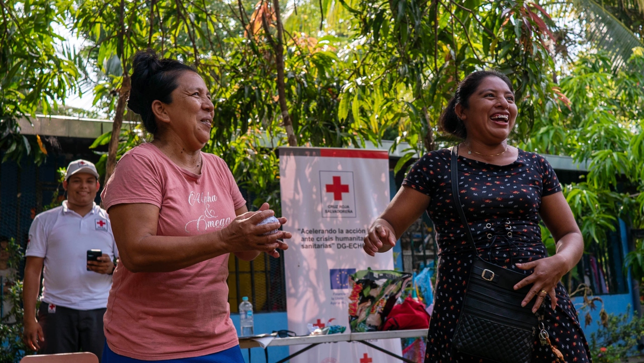 Dos mujeres participan en un ejercicio interactivo de preparación para desastres durante un taller organizado por la Cruz Roja Salvadoreña en el oeste de El Salvador.