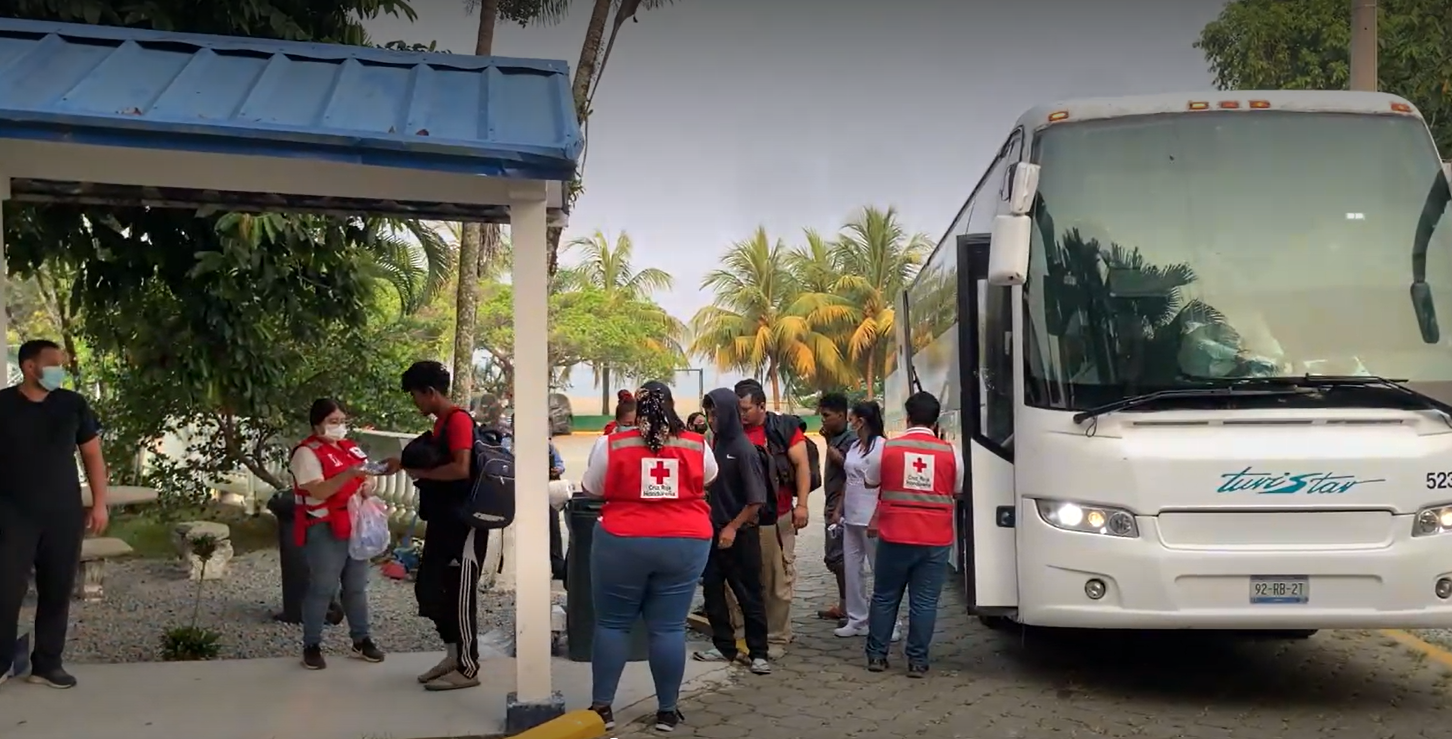 Honduran Red Cross volunteers greet people arriving by bus at the Centre for Attention to Returned Migrants (CAMR) in Omoa, north-west Honduras, where they will receive care and assistance.