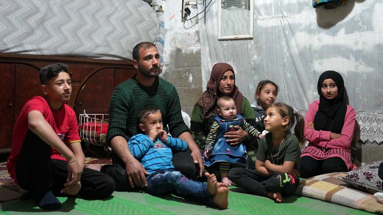 Ahmad Al Saleh from Syria sits with his wife and six children as he speaks to IFRC and Turkish Red Crescent staff about their experience of the 6 February earthquakes in Türkiye.