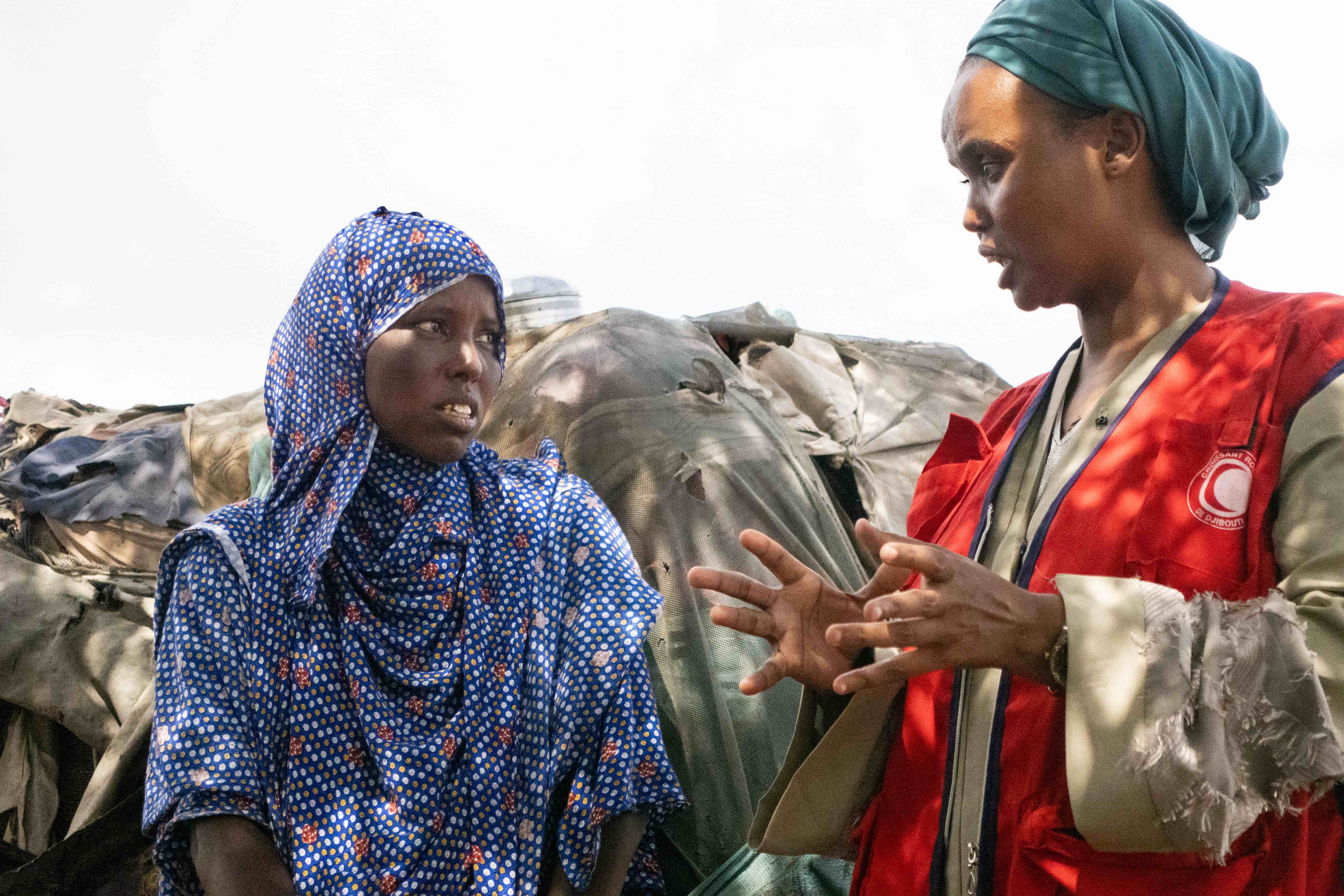 Djibouti Red Crescent volunteer speaks to person displaced from her home in Djibouti and is now living in an informal settlement.