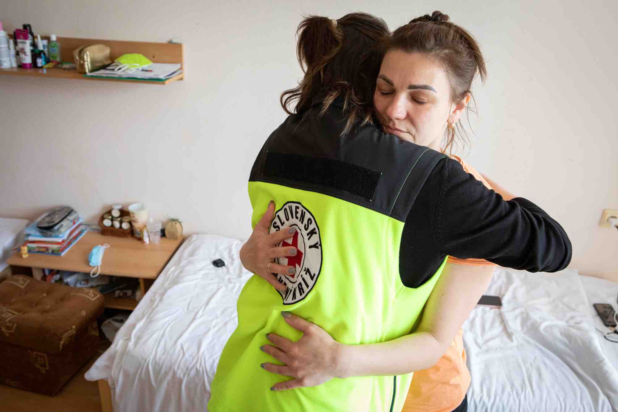 Une volontaire de la Croix-Rouge slovaque réconforte Larisa, une réfugiée ukrainienne, dans son appartement de Senica, en Slovaquie. 