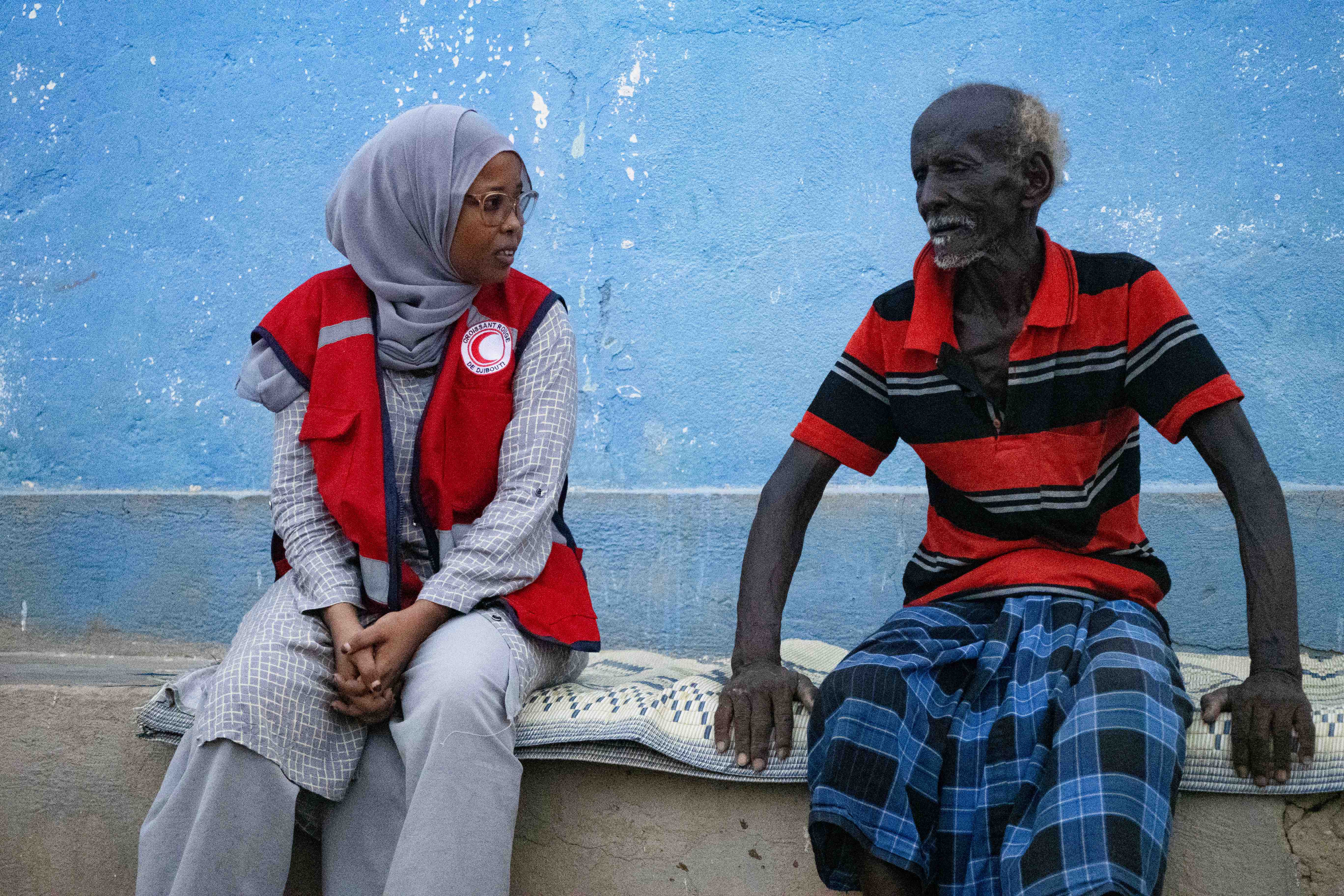 A Djibouti Red Crescent staff member listens to a man who received cash assistance from the Djibouti Red Crescent to help him face the challenges of recurring droughts.