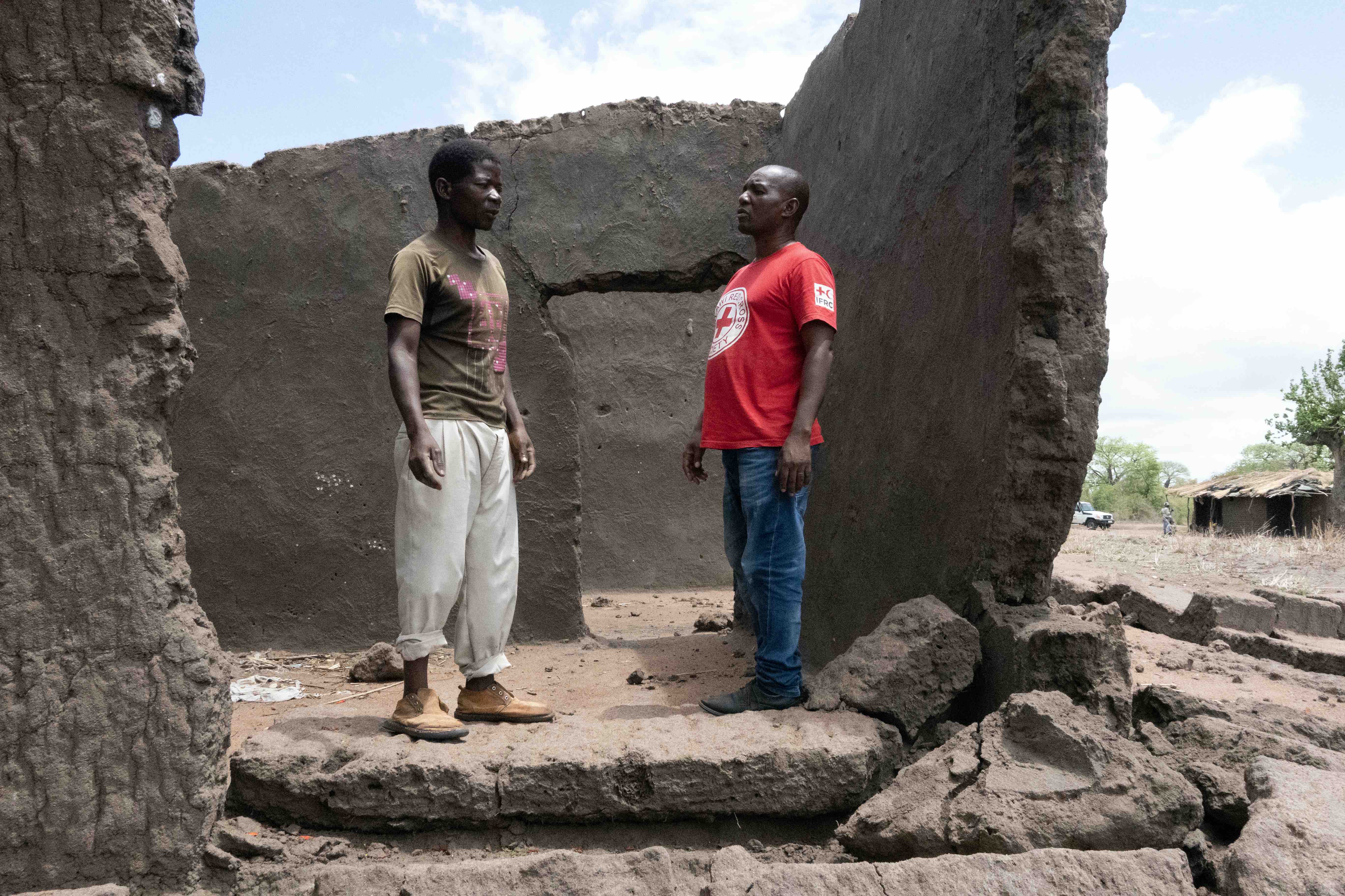 Malawi Red Cross with farmer whose home was destroyed by floods that also swept away his crops.