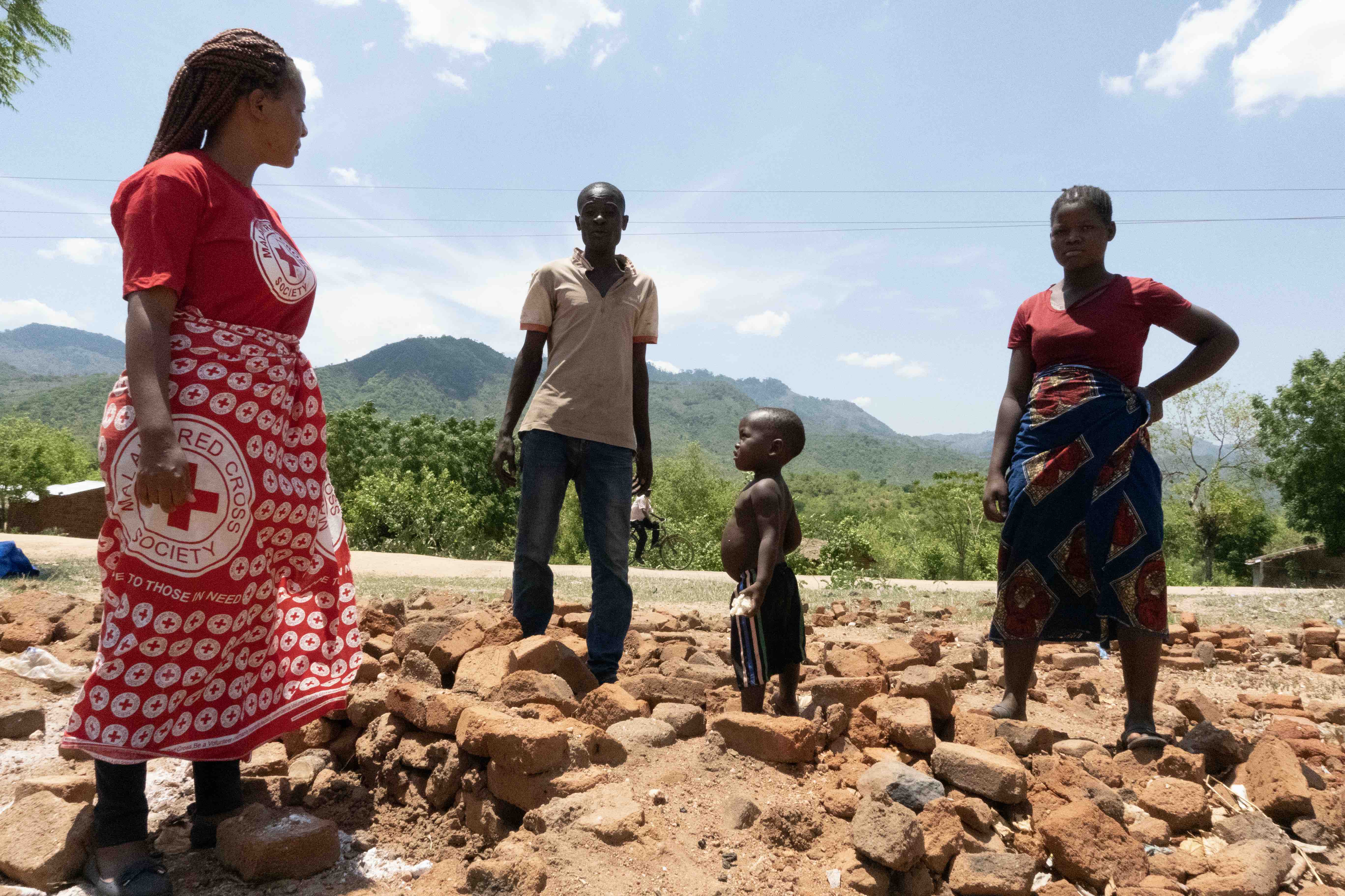 Malawi Red Cross with a family whose home and fields were washed away by floods from Cyclone Freddy in March 2023.